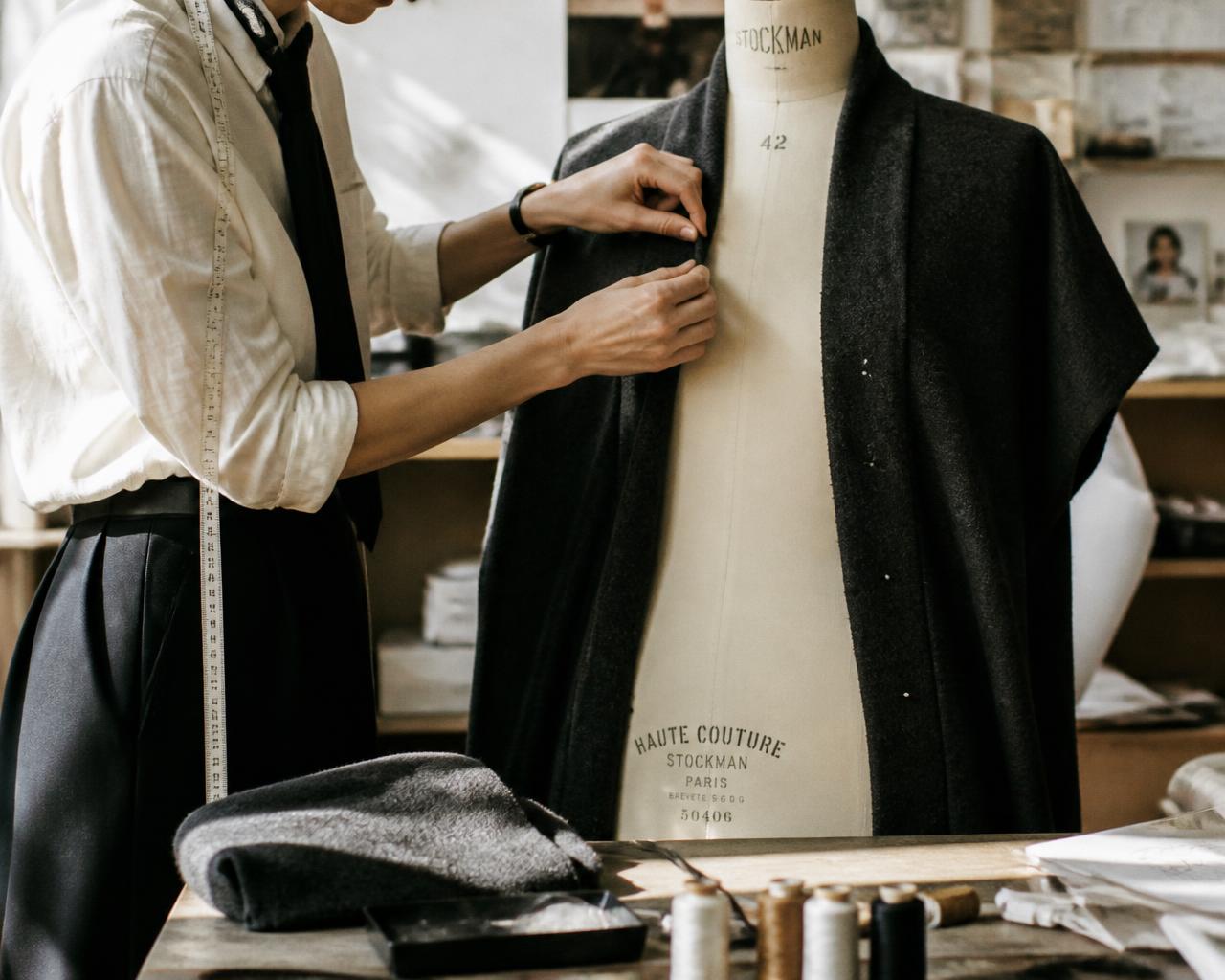 An ÉLARA cutter pinning a wool jacket on a dress form in the Bengaluru atelier